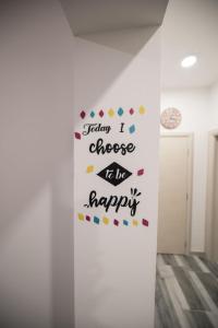 a wall with a sign that reads soon i choose to be happy at Hostel Evropa in Nikšić