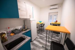 eine kleine Küche mit blauen Schränken und einer Arbeitsplatte in der Unterkunft Hostel Evropa in Nikšić