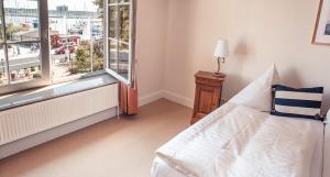 a bedroom with a bed and a large window at Strandhotel Strande in Strande