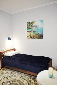 a bedroom with a bed and a painting on the wall at Apartments Provence in Chernivtsi