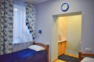 a bedroom with a bed and a clock on the wall at Apartments Provence in Chernivtsi