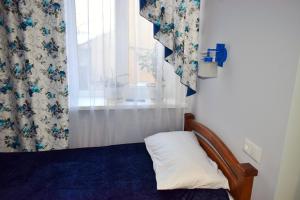 a bedroom with a bed and a window with curtains at Apartments Provence in Chernivtsi