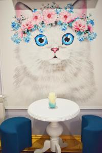 a cat with a flower crown on its head with a table at Apartments Provence in Chernivtsi