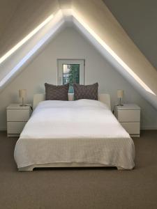 a bedroom with a large white bed in a attic at Studio Emilie in Detmold