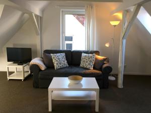 ein Wohnzimmer mit Sofa und Fernseher in der Unterkunft Studio Emilie in Detmold