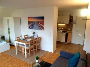 een woonkamer met een tafel en een keuken bij Wohlfühl-Apartment Bad Kissingen IV in Bad Kissingen