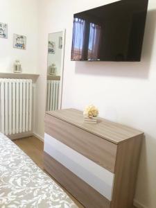 una cassettiera con una TV a schermo piatto su una parete di My Home a Lazise Altre 15 foto
