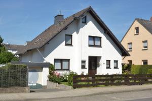 uma casa branca com um telhado preto em Ferienwohnung Heinen em Andernach
