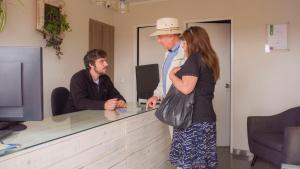 a man and a woman standing at a counter at Riomar Apart Hotel in Concón