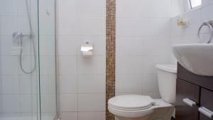 ein Bad mit einer Dusche, einem WC und einem Waschbecken in der Unterkunft Riomar Apart Hotel in Concón