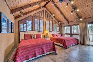 1 Schlafzimmer mit 2 Betten in einem Zimmer mit Fenstern in der Unterkunft Central Ruidoso Mountain Home, Steps to Downtown in Ruidoso