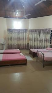 2 camas en una habitación con cortinas en Wli Water Heights Hotel, en Wli Afegame