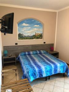 1 dormitorio con 1 cama y una pintura en la pared en Il Gatto e La Volpe, en Avigliana