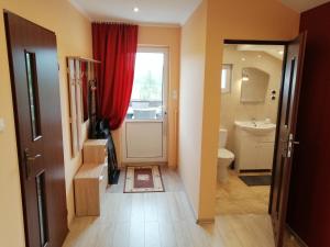 a bathroom with a red curtain and a toilet at Apartament TARA in Solina