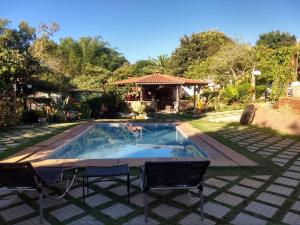 a swimming pool with two chairs and a gazebo at Pousada do Guinda DIAMANTINA -MG in Diamantina