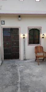Jaipur Haveli في جايبور: غرفه فارغه مع كرسي خشبي وباب