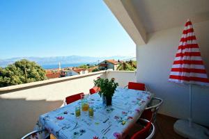 a table on a balcony with a view of the ocean at Apartments Jakšić - Žile in Supetar