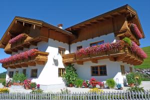 een wit huis met bloemen ervoor bij Tratlhof in Achenkirch