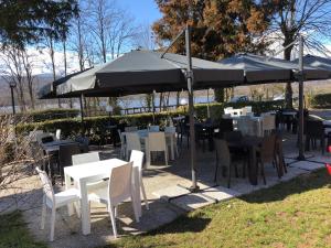 un groupe de tables et de chaises sous un parapluie dans l'établissement Il Gatto e La Volpe, à Avigliana