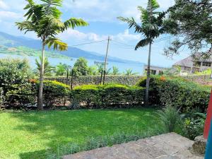 a garden with a view of the water at Palm Garden Resort in Gisenyi