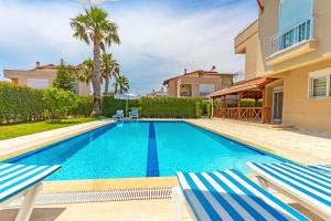 una piscina en una villa con 2 tumbonas en Paradise Town Villa Alison 100 MBPS free wifi, en Belek