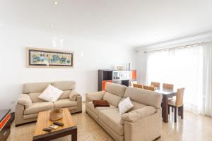 ein Wohnzimmer mit 2 Sofas und einem Tisch in der Unterkunft Chalet Can Parragó in Can Picafort