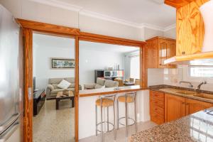 a kitchen with wooden cabinets and a living room at Chalet Can Parragó in Can Picafort