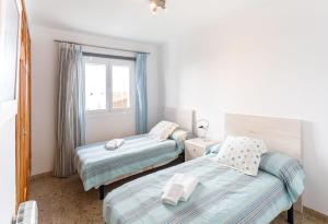 sypialnia z 2 łóżkami i oknem w obiekcie Chalet Can Parragó w Can Picafort