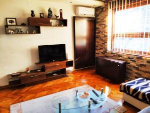 a living room with a couch and a table and a television at V2 with Love - Vintage Modern and Spacious in Belgrade