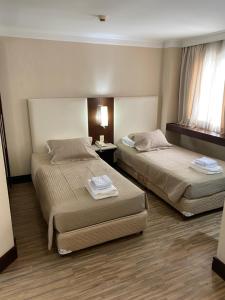 ein Hotelzimmer mit 2 Betten und einem Fenster in der Unterkunft Charmoso Flat na Alameda Santos in São Paulo