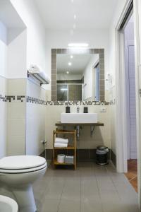La salle de bains est pourvue de toilettes blanches et d'un lavabo. dans l'établissement Gialel Pisa Guest House, à Pise