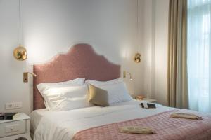 a bedroom with a large bed with a pink headboard at Bahar Boutique Hotel in Thessaloniki