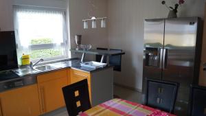 een keuken met een roestvrijstalen koelkast en een wastafel bij Ferienhaus Familie Müller in Altenrode