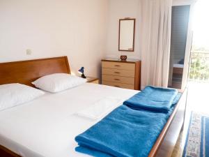 a bedroom with a bed with a blue blanket on it at Apartments Šarić in Makarska