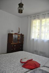 a bedroom with a bed and a dresser and a television at Le clos de Cantemerle in Saint-Sauveur