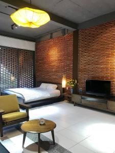 Ngói house في دا نانغ: غرفة نوم بسرير وتلفزيون في غرفة