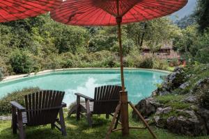 two chairs and an umbrella next to a pool at Casa Pepin in Posada