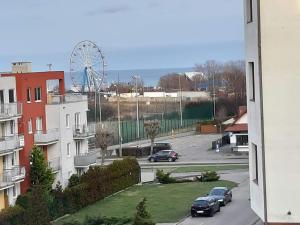 Blick auf eine Stadt mit einem Riesenrad in der Unterkunft Apartament Magdalenka in Władysławowo