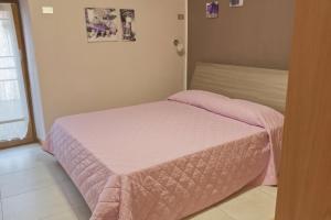 a small pink bed in a room with a window at B&B Casa a colori in Verona
