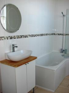 a bathroom with a sink and a tub and a mirror at The Clock House in Brewood