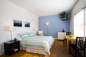 a bedroom with a bed and a desk and a tv at Venice Suites in Los Angeles +23 photos