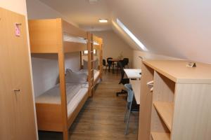 Schlafsaal mit Etagenbetten und einem Tisch in der Unterkunft Leidringer Gästehaus in Rosenfeld