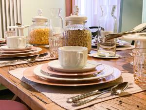 una mesa de madera con platos, jarras de vidrio y cubiertos en Rigoletto Charm, en Venecia