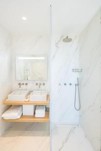 a white bathroom with a sink and a shower at Les Bords De Mer in Marseille