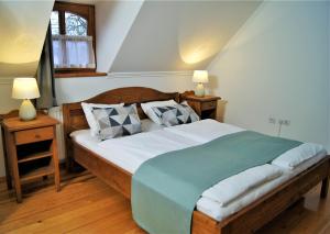 a bedroom with a large bed with two night stands and two lamps at Rácz Fogadó in Kisoroszi +68 photos