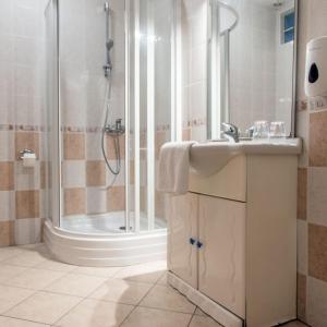 a bathroom with a sink and a shower at Rácz Fogadó in Kisoroszi