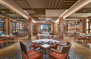 a dining room with tables and chairs and windows at Amari Vogue Krabi in Tab Kaek Beach