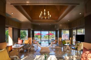 a living room with a chandelier and tables and chairs at Amari Vogue Krabi in Tab Kaek Beach