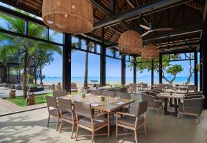 a dining room with tables and chairs and the ocean at Amari Vogue Krabi in Tab Kaek Beach