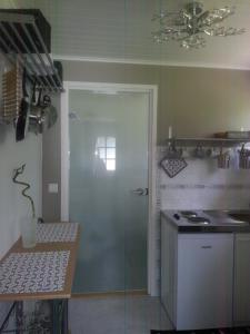 a kitchen with a glass shower door and a sink at Poppelstrand Nuuksio, Pet friendly guest apartment in Nuuksio